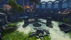 The free-for-all arena in the Heart of the Mists, a round area with high circular walls around the edges, a circulate grate in then middle with 3 stone pillars and a pile of rubble in a square around it.